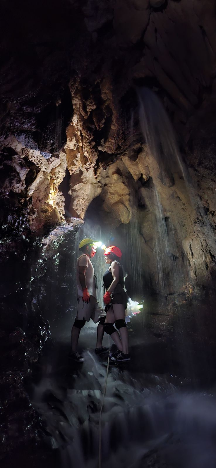 Dos exploradores con casco y linterna dentro de la cueva