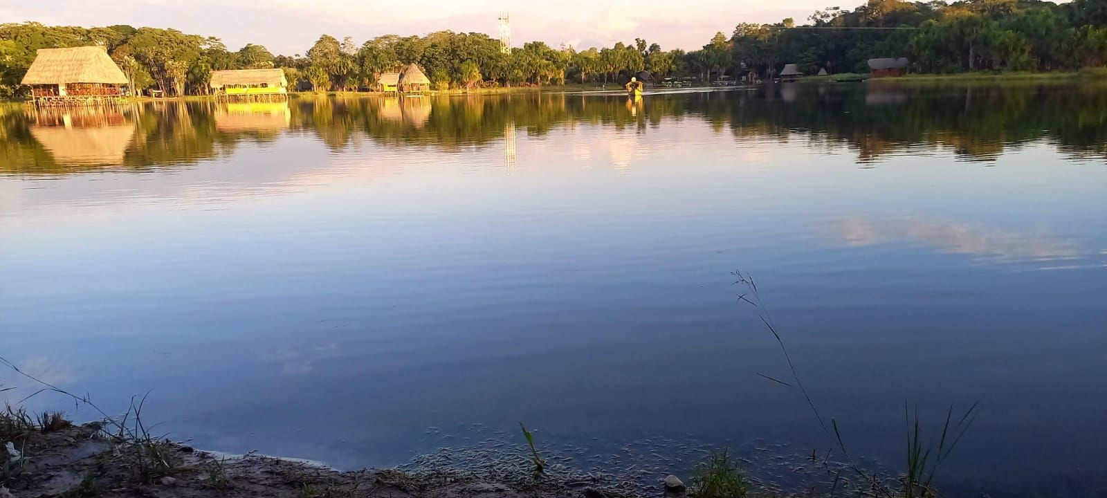 La Laguna de los Milagros al atardecer, con el agua en calma y cerros al fondo